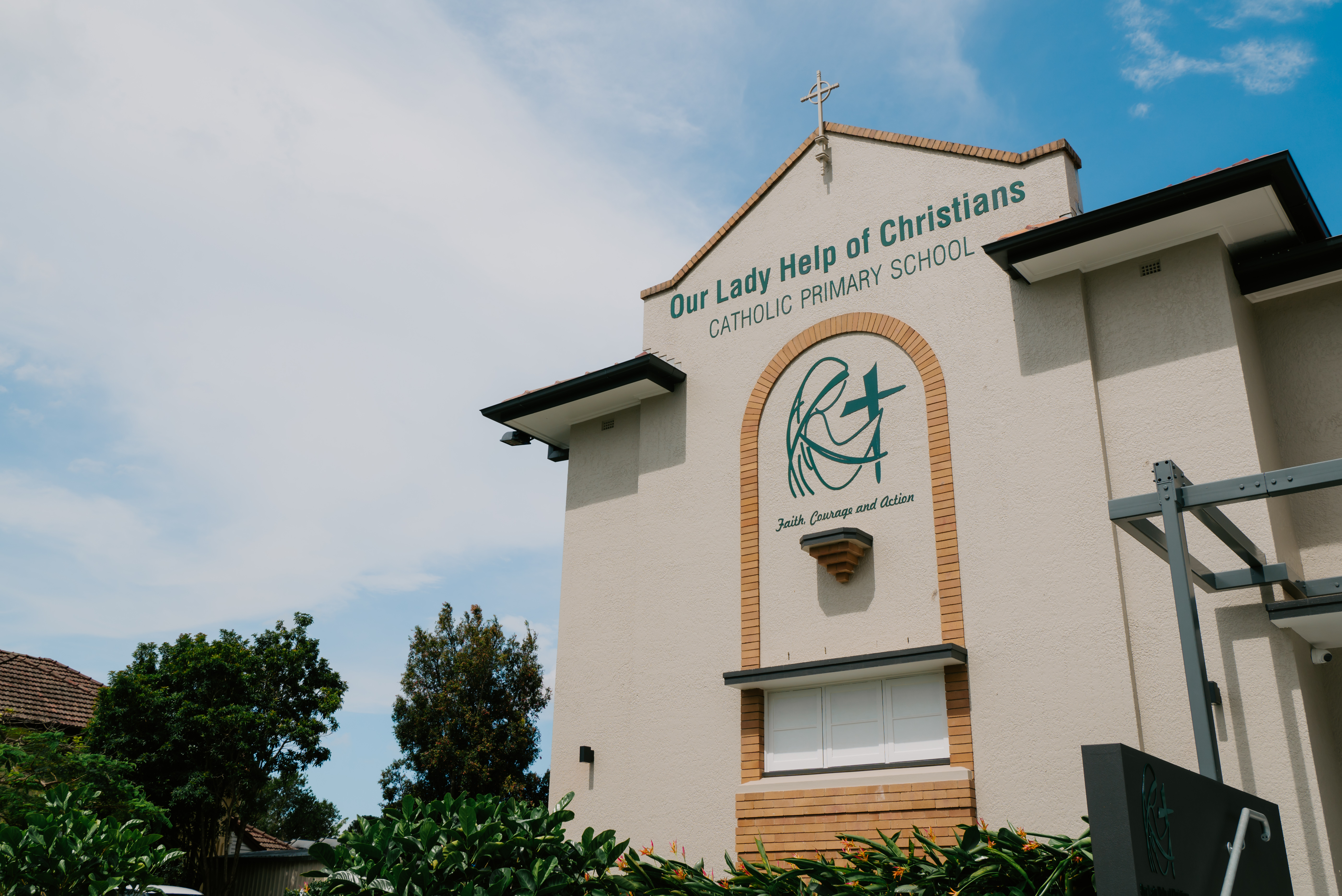 School building signage of Our Lady Help of Christians Catholic Primary School, representing Catholic identity and community presence